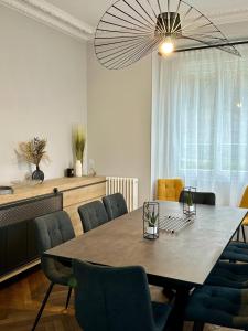 einen Esstisch mit Stühlen und einem großen Kronleuchter in der Unterkunft Le Magnolia Maison 12 Couchages in Dieppe