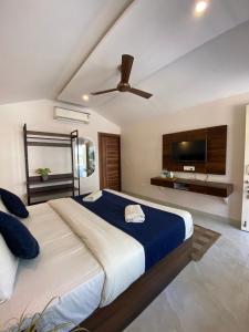a bedroom with a large bed with a ceiling fan at Glampers Resort Rishikesh at River Side in Rishīkesh +7 photos