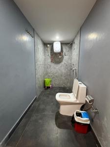 a bathroom with a white toilet in a room at Glampers Resort Rishikesh at River Side in Rishīkesh