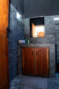 a bathroom with a wooden cabinet and a mirror at Ninety Four Plus Madiha in Matara