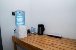 a bottle of water sitting on top of a wooden table at Ninety Four Plus Madiha in Matara