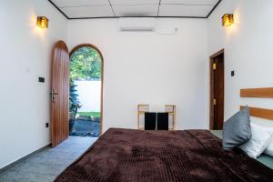 a bedroom with a bed and an open door at Ninety Four Plus Madiha in Matara