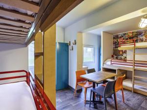 a room with a table and chairs and a bunk bed at HotelF1 Perpignan Sud in Perpignan +94 photos