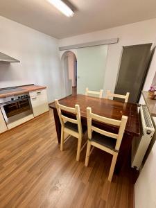 a kitchen with a wooden dining table and chairs at Herzo City Apartment - bis zu 8 Personen - 4 Schlafzimmer - Innenstadt in Herzogenaurach