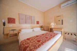 a bedroom with a bed and a desk with a phone at Hotel Derby in Riccione