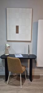 a black desk with a chair and a lamp at Les Murs By le Clos in Metz