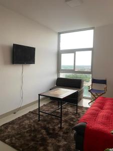 a living room with a couch and a tv on a wall at Familiar, Fresco y Relax Atlantis in Santa Cruz de la Sierra