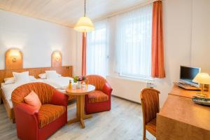 a hotel room with a bed and a table and chairs at Hotel Flora in Bad Harzburg
