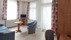 a living room with a couch and chairs and a table at Hotel Flora in Bad Harzburg