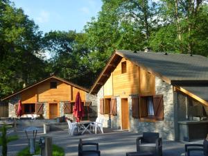 a barn with tables and chairs in front of it at Gîtes et yourte le Tucaou avec bains nordiques in Camous +15 photos