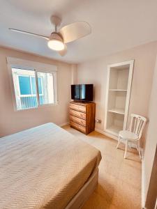 a bedroom with a bed and a tv and a chair at Piso en Centro-Fortaleza Santa Pola in Santa Pola +21 photos