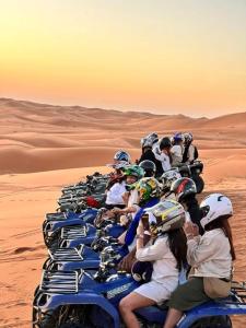 un grupo de personas montando motocicletas en el desierto en Hotel Dar Sahara, en Merzouga