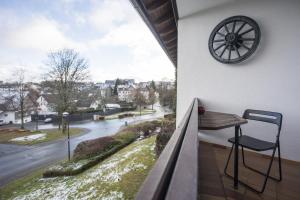 a balcony with a table and a clock and a street at Welcome in - Appartement centraal gelegen met balkon - Heidestrasse 2 Winterberg in Winterberg +20 photos