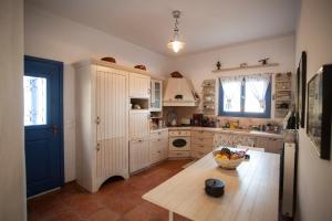 a kitchen with a table with a bowl of fruit on it at Alia's sea view villa & studios in Apróvaton