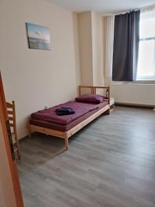 Pension am Bahnhof Mühlhausen في مولهاوزن: غرفة نوم بسرير في زاوية الغرفة