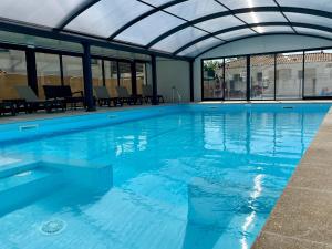 una gran piscina con techo abovedado en Charming ecolodge with heated pool all year round, en Les Mathes