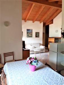 a room with a table with a pot of flowers on it at Villa Primula in Molveno