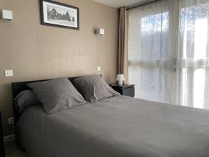 a bedroom with a large bed with a window at Gites et camping le Sédour in Riom-ès-Montagnes