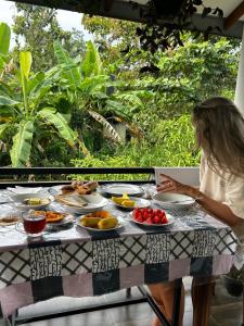 a woman sitting at a table with plates of food at Villa Tharu in Hikkaduwa
