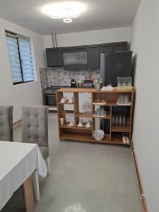 una cucina con un tavolo e uno scaffale con oggetti di Popas La Vintu  Altre 26 foto
