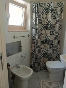 a bathroom with a toilet and a shower curtain at Casa Canale in Gesualdo