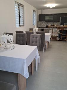 una sala da pranzo con tavoli e sedie bianchi di Popas La Vintu 