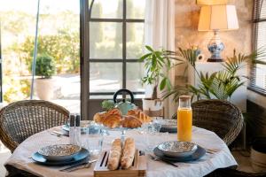 a table with a plate of bread and orange juice at La Mouline sublime domaine privatif avec piscine à Pézenas in Pézenas
