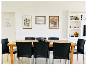 LA ESQUINA DE LA FLOR في Campo Quijano: غرفة طعام مع طاولة خشبية وكراسي سوداء +3 صور