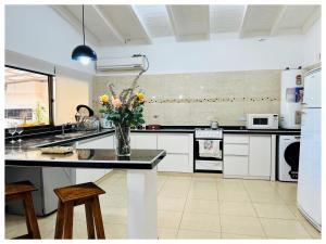 LA ESQUINA DE LA FLOR في Campo Quijano: مطبخ مع إناء من الزهور على منضدة