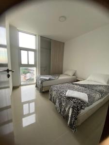 two beds in a room with a window at Exclusive, Elegant Atlantis Comfortable in Santa Cruz de la Sierra +27 photos