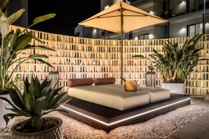 a couch sitting on a platform in a courtyard with plants at Hotel Vibra Yamm Urban - Adults only in San Antonio