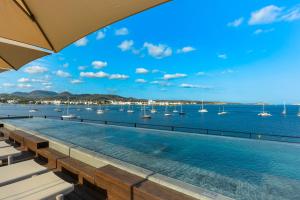 a swimming pool with a view of the water and boats at Hotel Vibra Yamm Urban - Adults only in San Antonio