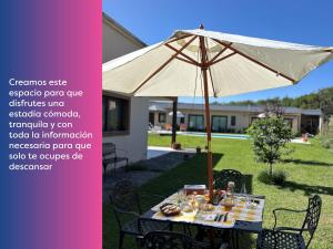 LA ESQUINA DE LA FLOR في Campo Quijano: طاولة مع مظلة في الفناء