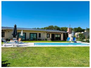 LA ESQUINA DE LA FLOR في Campo Quijano: منزل به مسبح وبه كراسي ومظلات