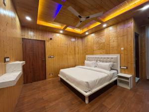 Wood Luxury Hotels Kasauli في كاساولى: غرفة نوم بها سرير وجدار خشبي