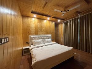 Wood Luxury Hotels Kasauli في كاساولى: غرفة نوم بها سرير في جدار خشبي