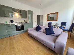 a living room with a couch and a kitchen at 3 Bed - Maisonette - Albert Road in Morecambe