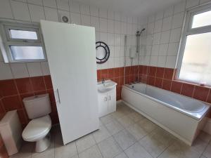 a bathroom with a toilet and a tub and a sink at 3 Bed - Maisonette - Albert Road in Morecambe