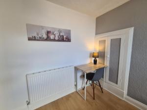a room with a desk and a table with a lamp at 3 Bed - Maisonette - Albert Road in Morecambe +3 photos