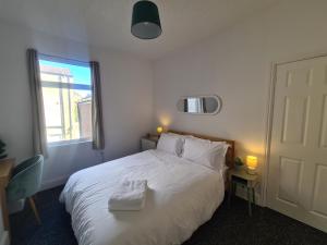 a bedroom with a bed with two towels on it at 3 Bed - Maisonette - Albert Road in Morecambe