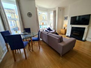 a living room with a couch and a table and chairs at 3 Bed - Maisonette - Albert Road in Morecambe