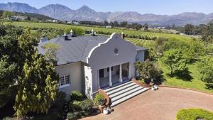an aerial view of a house with mountains in the background at 13 Olives, Entire Grape & Olive Estate, Somerset West by Euphoric Leisure in Sir Lowryʼs Pass