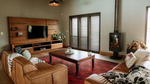 a living room with a couch and a coffee table at 13 Olives, Entire Grape & Olive Estate, Somerset West by Euphoric Leisure in Sir Lowryʼs Pass