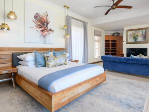 ein Schlafzimmer mit einem großen Bett und einer blauen Couch in der Unterkunft 11 On Fairway Villa by Euphoric Leisure in Southbroom + 23 Fotos