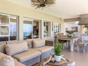 ein Wohnzimmer mit Sofa und Tisch in der Unterkunft 11 On Fairway Villa by Euphoric Leisure in Southbroom