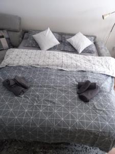 a bed with two black slippers on top of it at Apartman Afano in Jahorina +10 photos