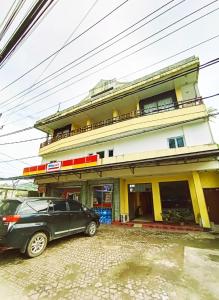 due auto parcheggiate davanti a un edificio di Citepus Indah Hotel a Citepus