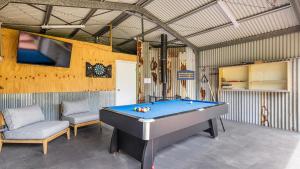 Habitación con mesa de billar y TV. en Salt and Serenity - Lux Home With Heated Pool, en Anna Bay