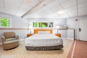 ein Schlafzimmer mit einem Bett und einem Stuhl in der Unterkunft Cedar Park Inn in North Stonington