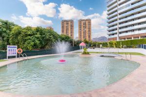 a fountain in a pool with buildings in the background at Amazing Apartment in Benidorm - Sunset in Benidorm